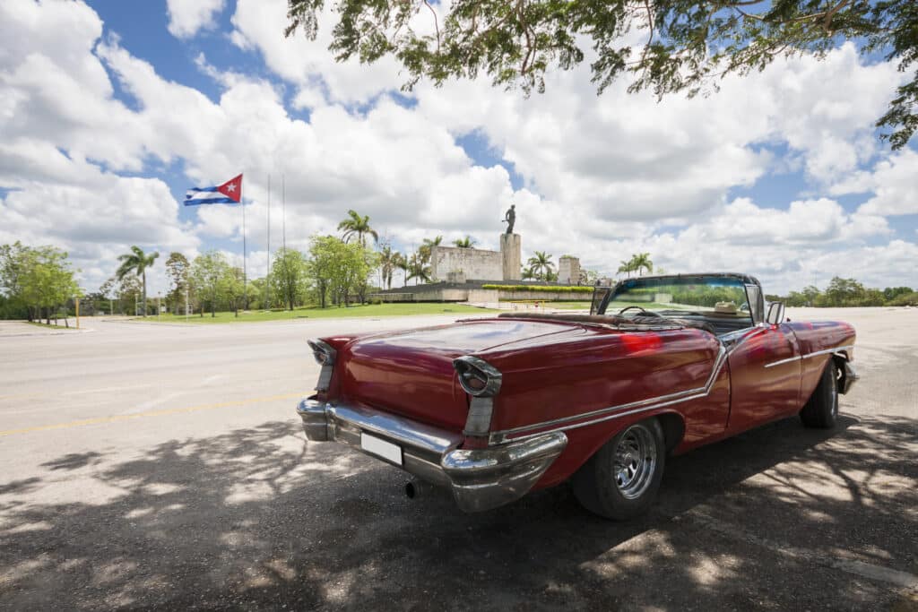 classic-convertible-car-with-monument-cuban-flag-background